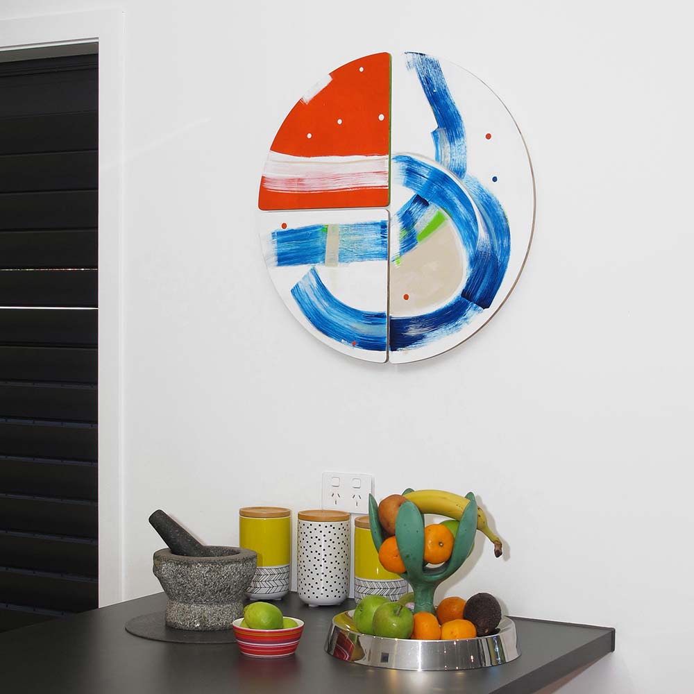 Swashbuckle Peg wall sculpture by Kirsty Black installed on a white wall above a dark kitchen bench with fruit, canisters and a mortar and pestle, showing the work&