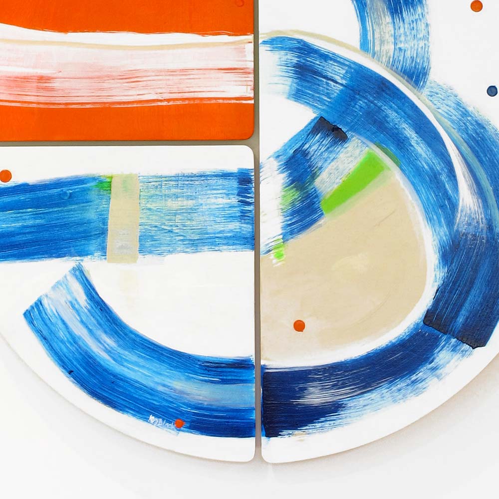 Detail of Swashbuckle Peg wall sculpture by Kirsty Black showing sweeping cobalt blue arcs encircling a soft beige form with a vivid green accent block and orange dot detail across adjoining bevelled plywood tiles.