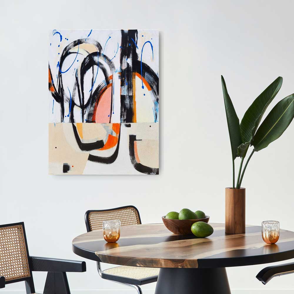 Brouhaha abstract painting by Kirsty Black hung on white wall above dark timber dining table with cane chairs, wooden bowl and tropical plant, showing scale of 1000x760mm canvas in contemporary dining space