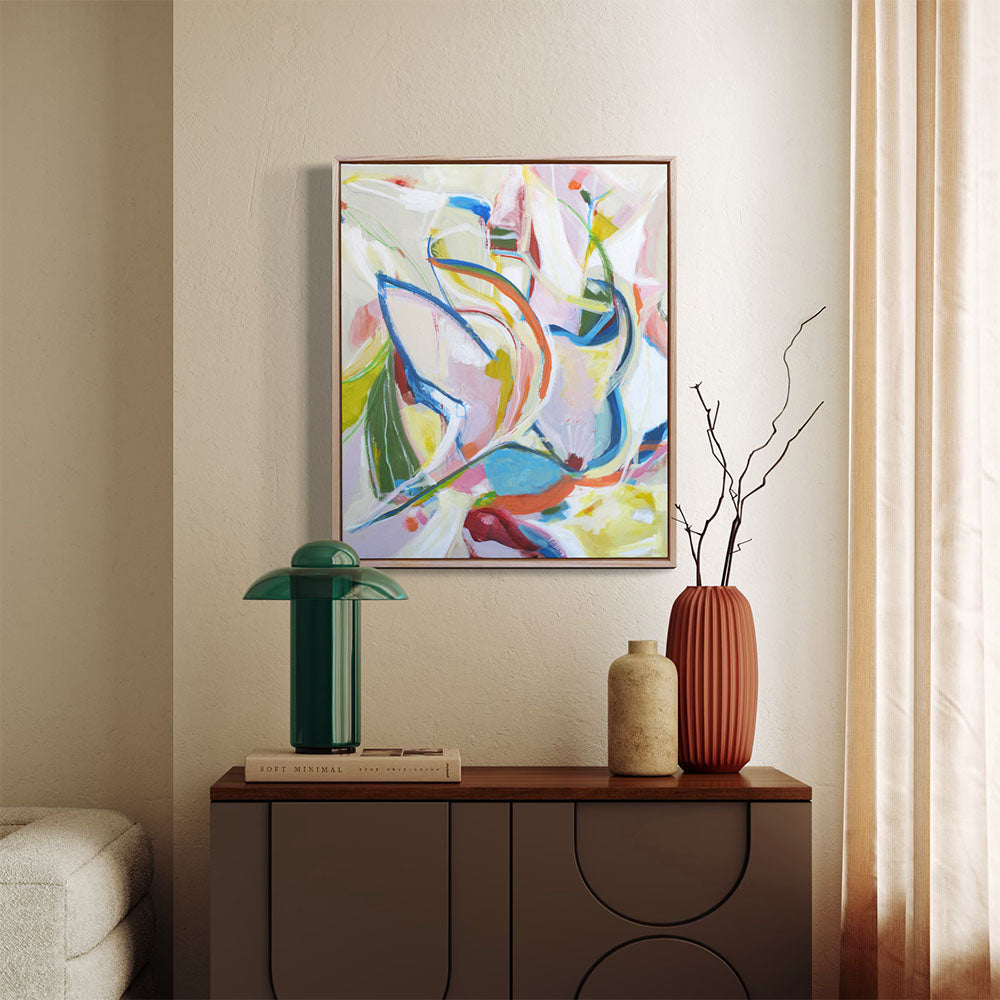 Budgie Bustle abstract painting by Kirsty Black in a natural timber float frame, hung on a teal wall above a wooden shelf styled with a grey teapot and ceramic cups.