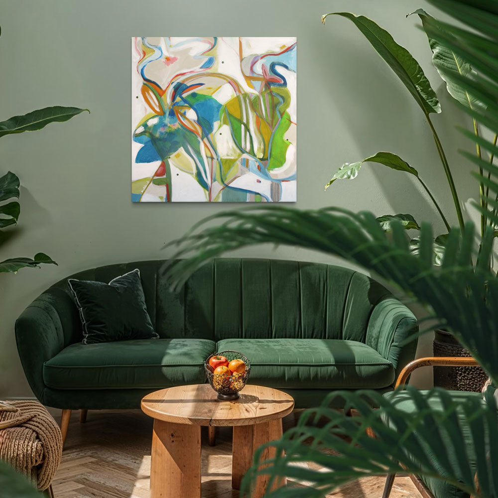 Critter Masquerade abstract painting by Kirsty Black on sage green wall above emerald green velvet sofa with tropical plants and round wood coffee table
