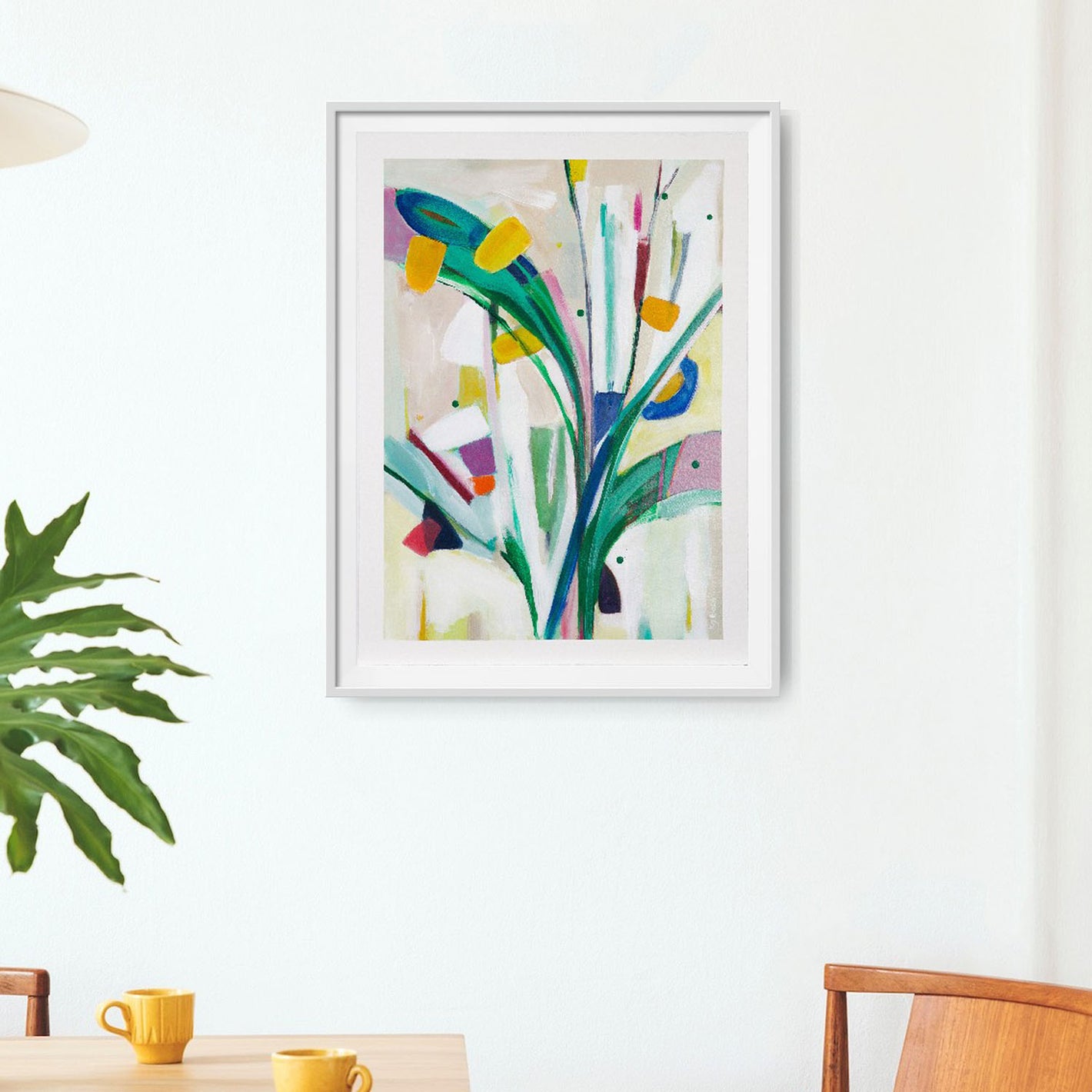 Colourful abstract painting  on paper in a  float mounted with a white frame hanging on a white wall