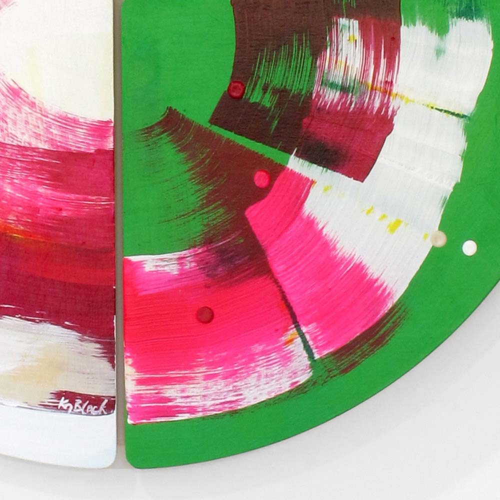 Detail of Roller Disco Dames wall sculpture by Kirsty Black showing sweeping hot pink and magenta brushwork on vivid green with dark burgundy accents and artist signature on the bevelled plywood edge.