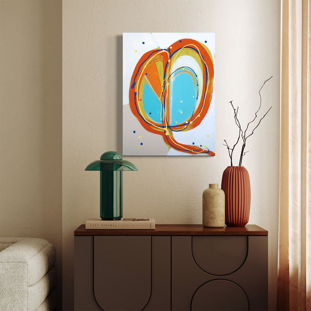 Rosella Dive Bomb abstract painting by Kirsty Black hung on warm plaster wall above timber sideboard styled with green domed lamp, ceramic vases and dried branches, showing scale of 600x450mm portrait format in contemporary living space