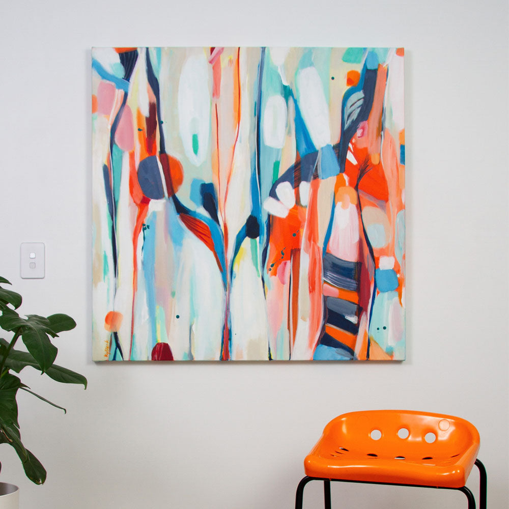 Bold abstract painting Tiger Tipple by Kirsty Black hanging on white wall with plant & orange stool