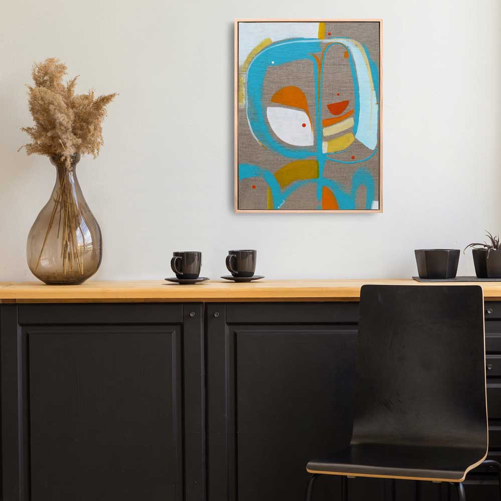 Tip Top Turvy framed abstract painting by Kirsty Black hung on white wall above black kitchen cabinet with timber benchtop, black ceramic cups, pampas grass in glass vase and black chair