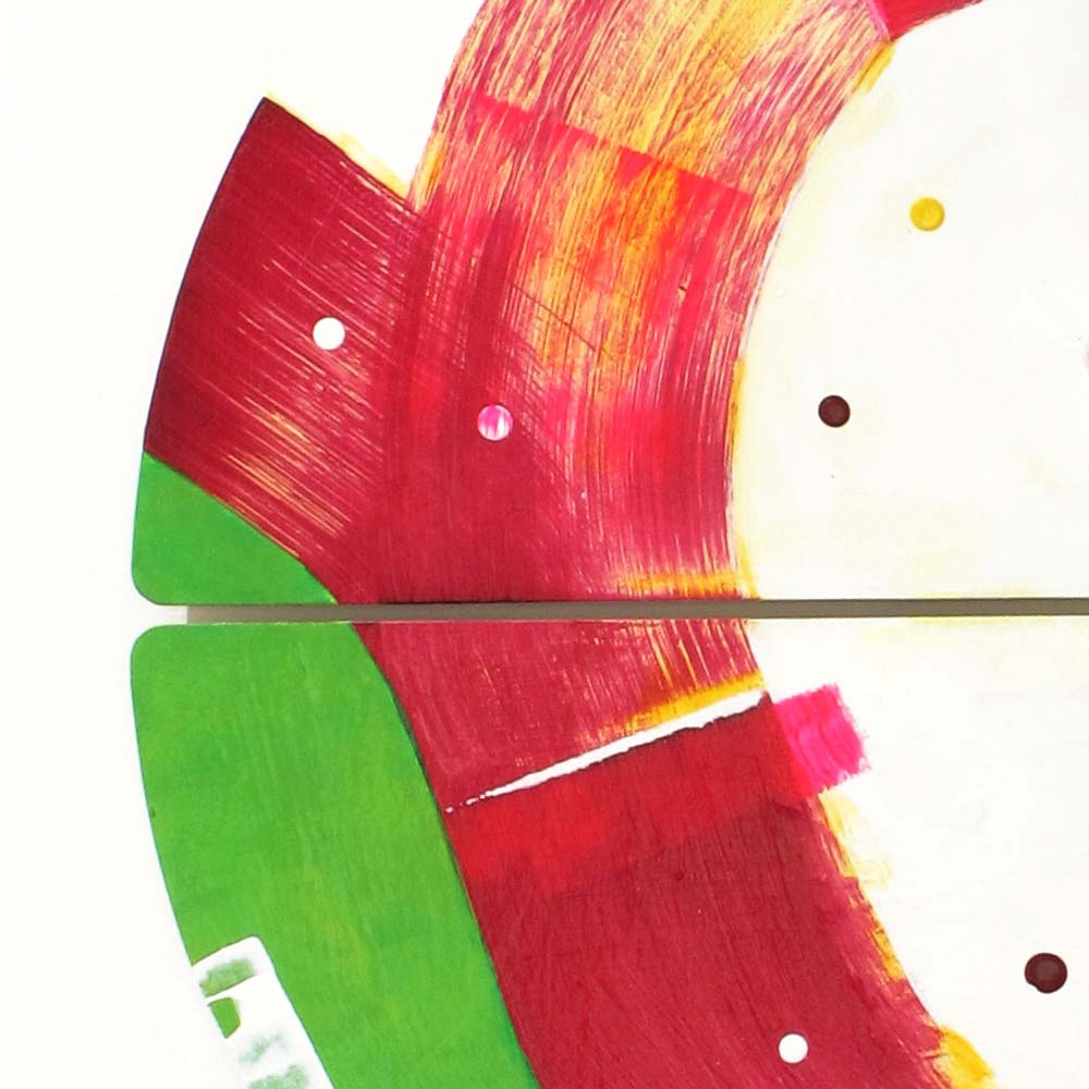Close-up of Sausage Dog Wheelie wall sculpture by Kirsty Black showing bold crimson and yellow brushwork sweeping across two bevelled plywood tiles with a vivid green arc and scattered dot accents at the panel join.