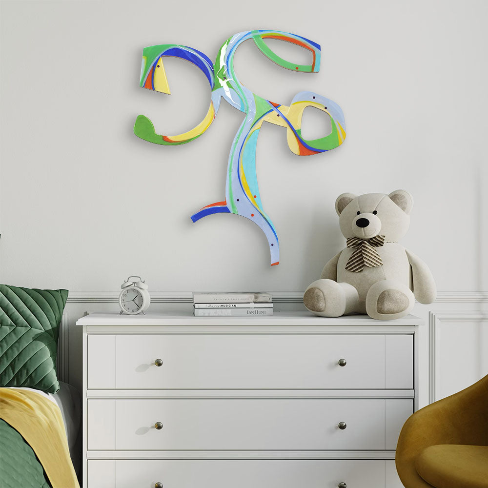 Cartwheeling Crustacean wall sculpture by Kirsty Black above a white chest of drawers in a styled bedroom with green bedding and a teddy bear.
