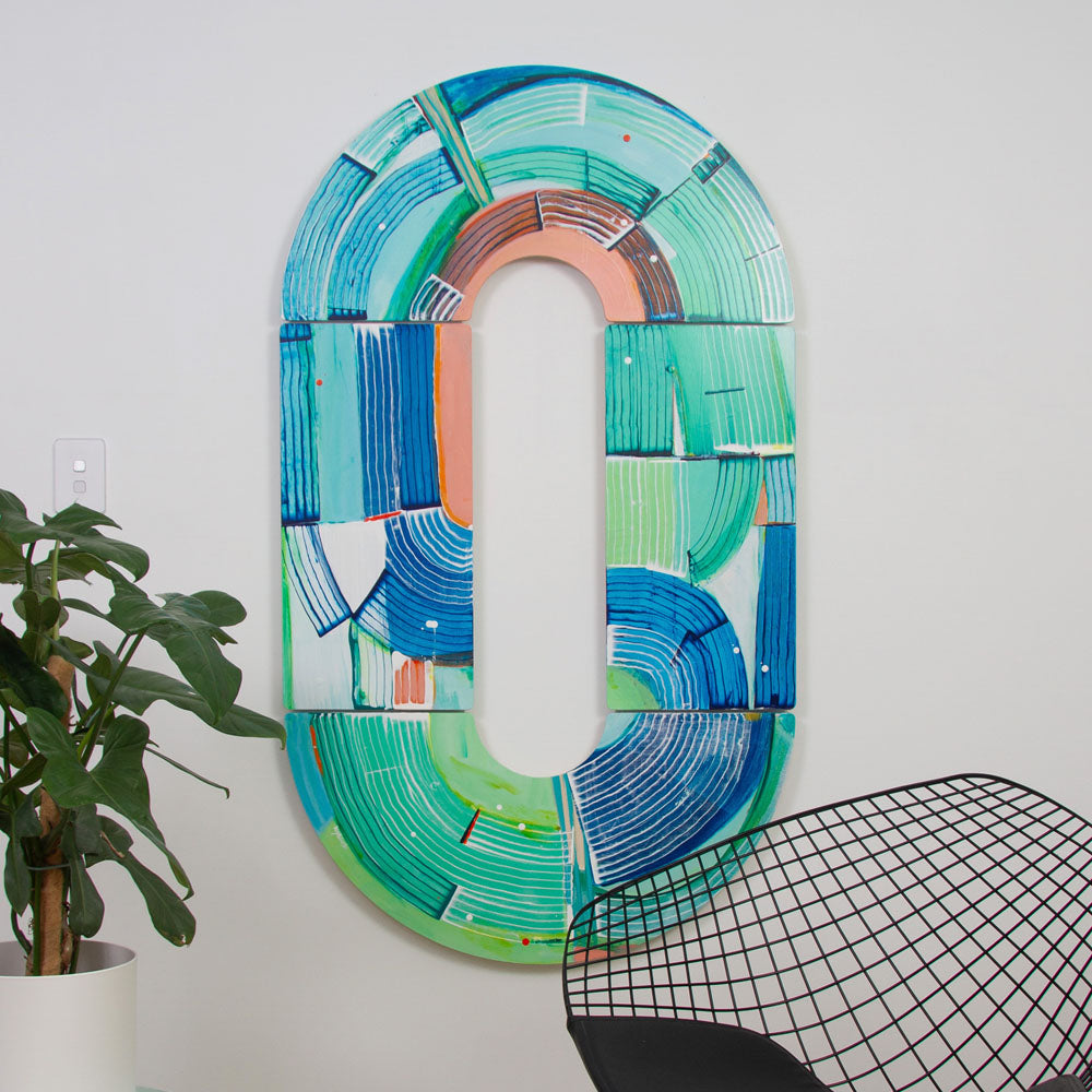 Otter Wingding, abstract wall sculpture hanging vertically on a white wall