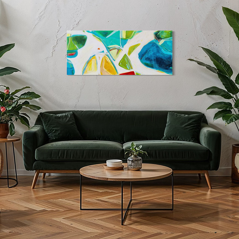 Jet Set Jaunt original abstract painting by Kirsty Black hung horizontally on concrete wall above dark green velvet sofa flanked by tropical plants, showing scale of 1220x508mm landscape format canvas in contemporary living room with herringbone timber floor