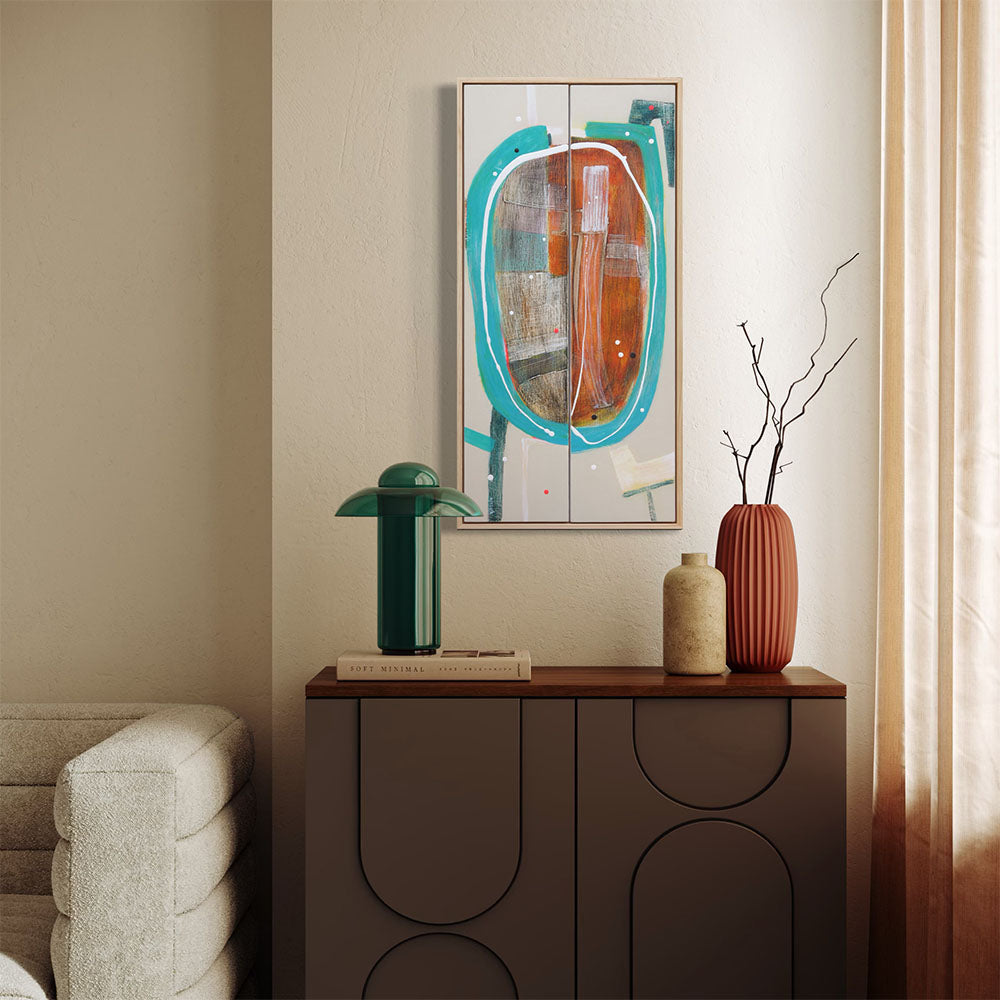 Racetrack Rumble framed abstract diptych by Kirsty Black hung above dark timber sideboard in warm contemporary living space with teal mushroom lamp, terracotta ribbed vase and dried branch arrangement